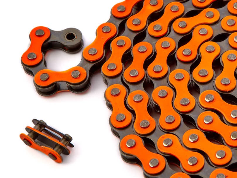 Nahaufnahme Fahrradkette und Kettenschloss in Orange Nahaufnahme Fahrradkette und Kettenschloss in Orange