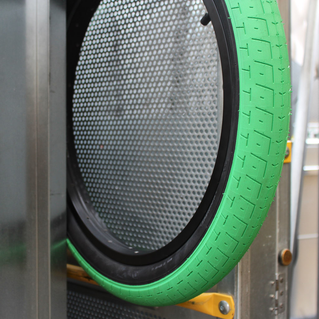 Nahaufnahme von Reifen auf schwarzer Felge mit grünem Profil und schwarzem Innenring