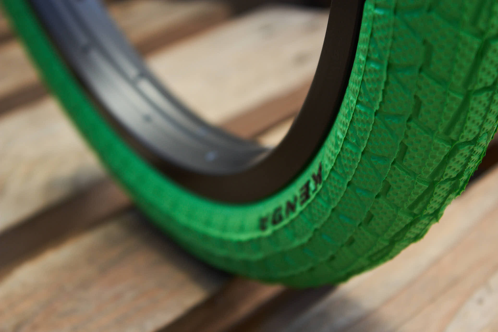 Nahaufnahme schwarzes KENDA Logo auf grünem Reifen